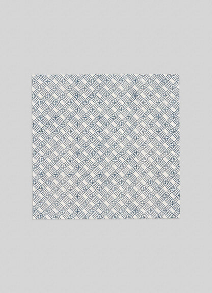 The Viya Paigah Navy Napkins (Set of 4) feature a square design with blue interlocking circle patterns inspired by Indo-Islamic paigah jaalis on a white background, shown against a plain light gray surface.