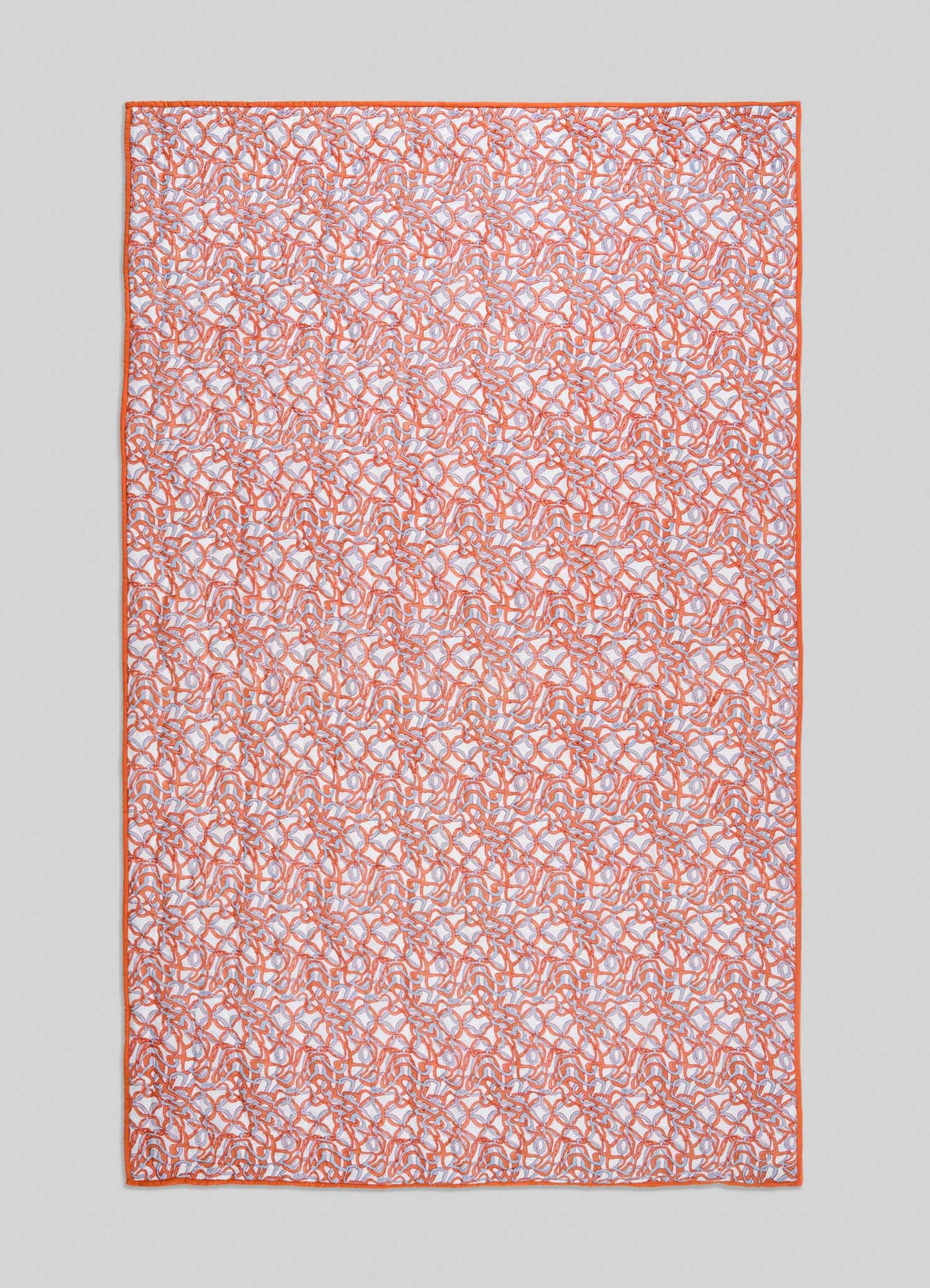 The Viya Paigah Orange & Blue Single Quilt is a rectangular fabric displaying intricate orange and blue Indo-Islamic abstract patterns with a solid orange border, shown against a light gray background.