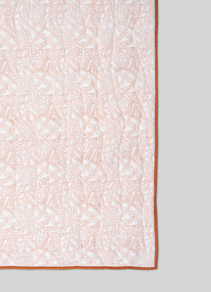 The Viya Paigah Orange & Blue Single Quilt features an intricate light brown abstract pattern inspired by paigah jaalis on white fabric, bordered with solid brown and set against a light gray background.