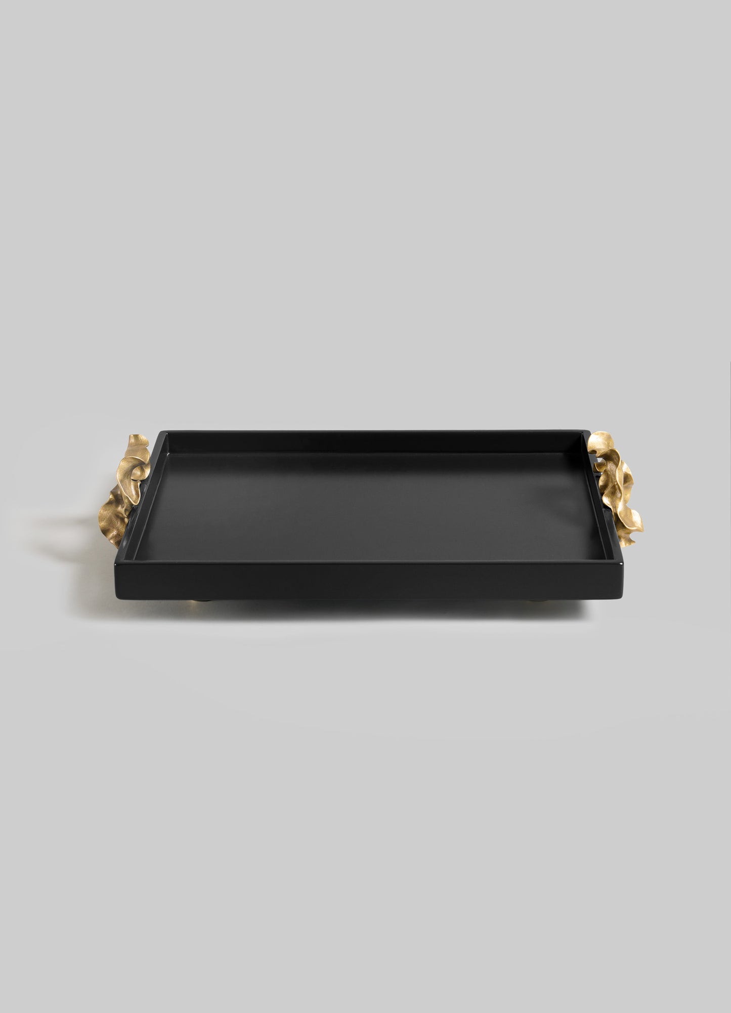 The VIYA Saffron Black Towel Tray features a rectangular black design with raised edges and elegant gold-toned handles, evoking contemporary style, displayed against a plain light gray background.