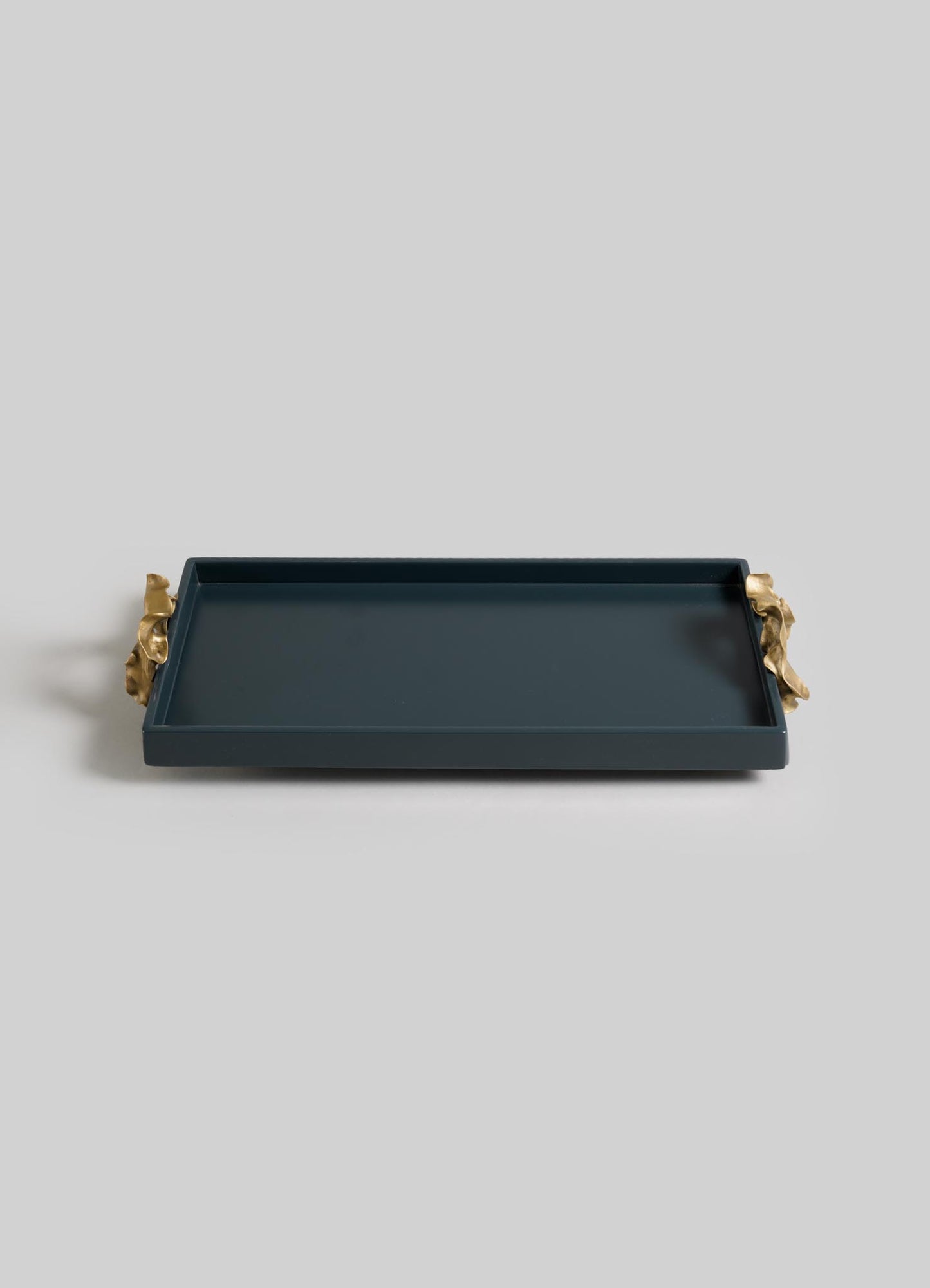 The VIYA Saffron Dark Blue Vanity Tray is a rectangular serving tray with raised edges and gold handles inspired by ancient Indian medicine, shown on a plain light gray background.