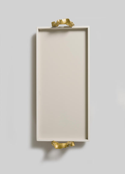 The Saffron Ecru Vanity Tray by VIYA features a rectangular white design with gold sculpted handles, inspired by contemporary bronzed objects, shown on a light grey background.