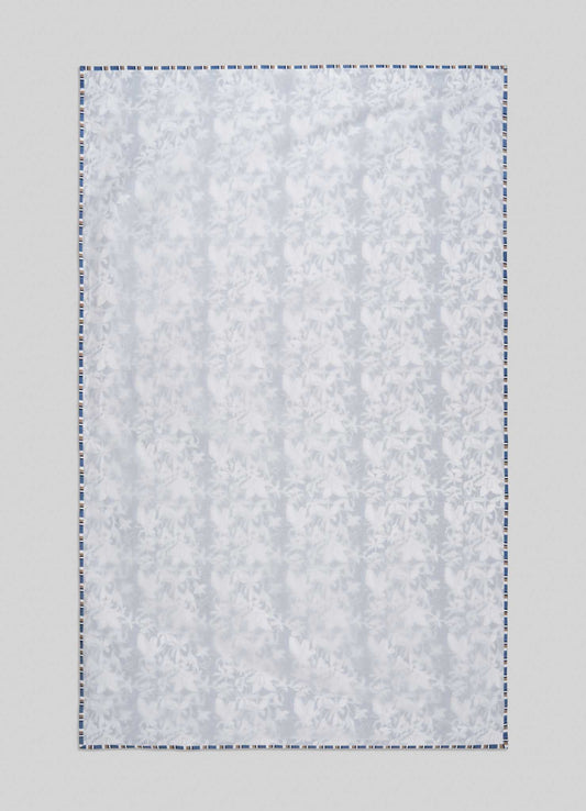 The Viya Spring Bouquet Blue Single Dohar features a subtle floral pattern inspired by Indian gardens, finished with a blue-and-white border, and is displayed flat against a light gray background.