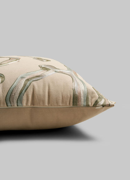 A close-up side view of the Viya Tutti Frutti Sea Green Cushion Cover (24"x24") shows its botanical leaf pattern in green, white, and pink tones, resembling hand embroidery, set against a plain grey background.